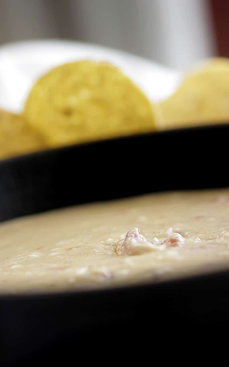 creamy white queso in cast iron skillet surrounded by tortilla chips