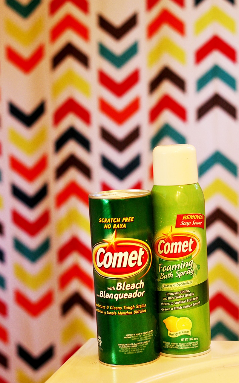 comet powder and comet foaming bath spray on tub ledge with multi color shower curtain