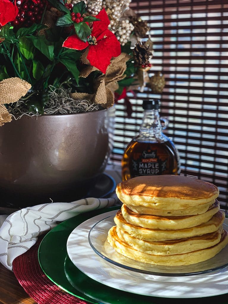 fluffy eggnog pancakes on plate with maple syrup