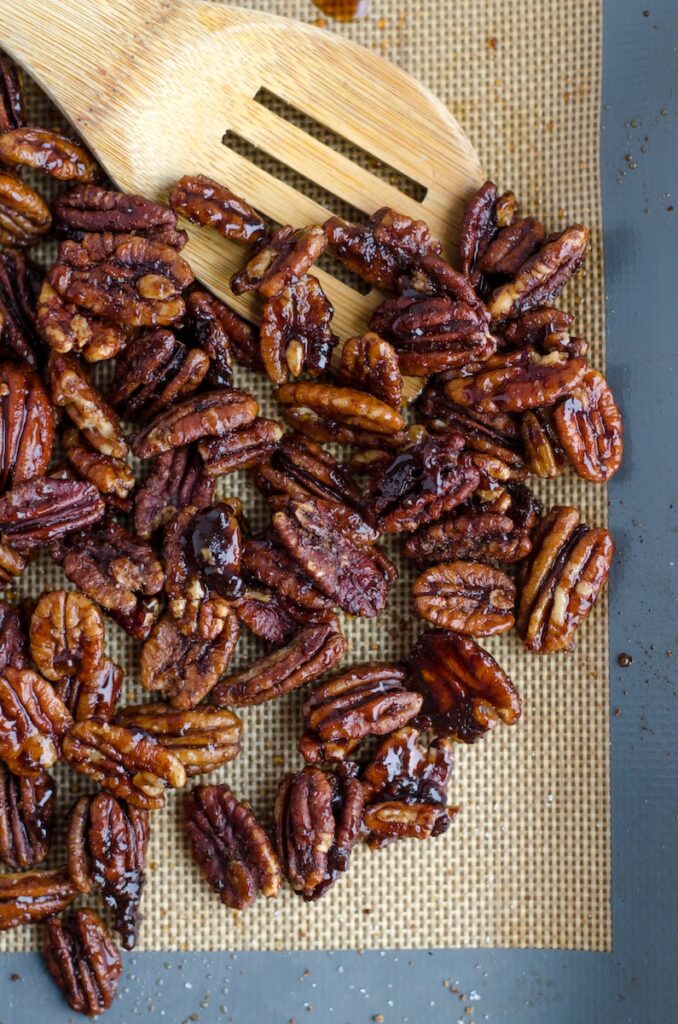 cooked pecans beside brown wooden ladle