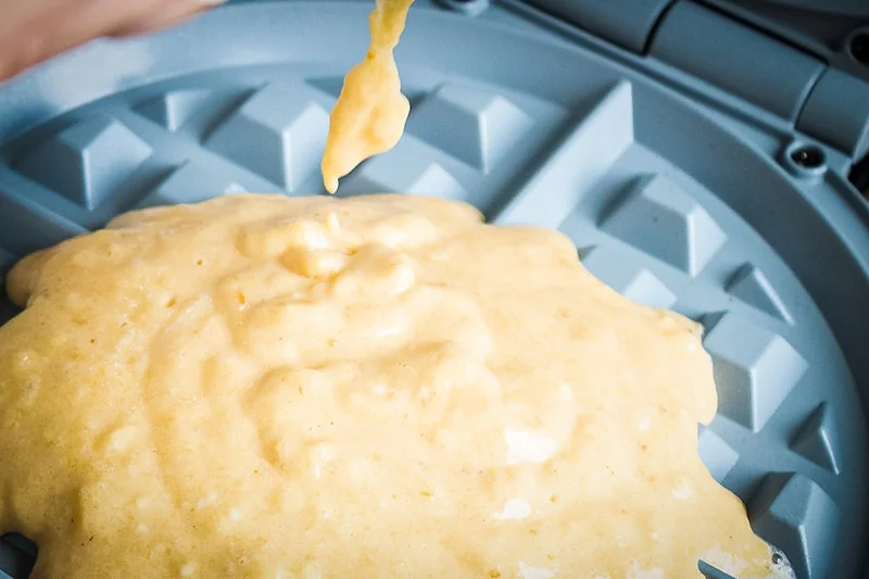 putting waffle mix on waffle iron